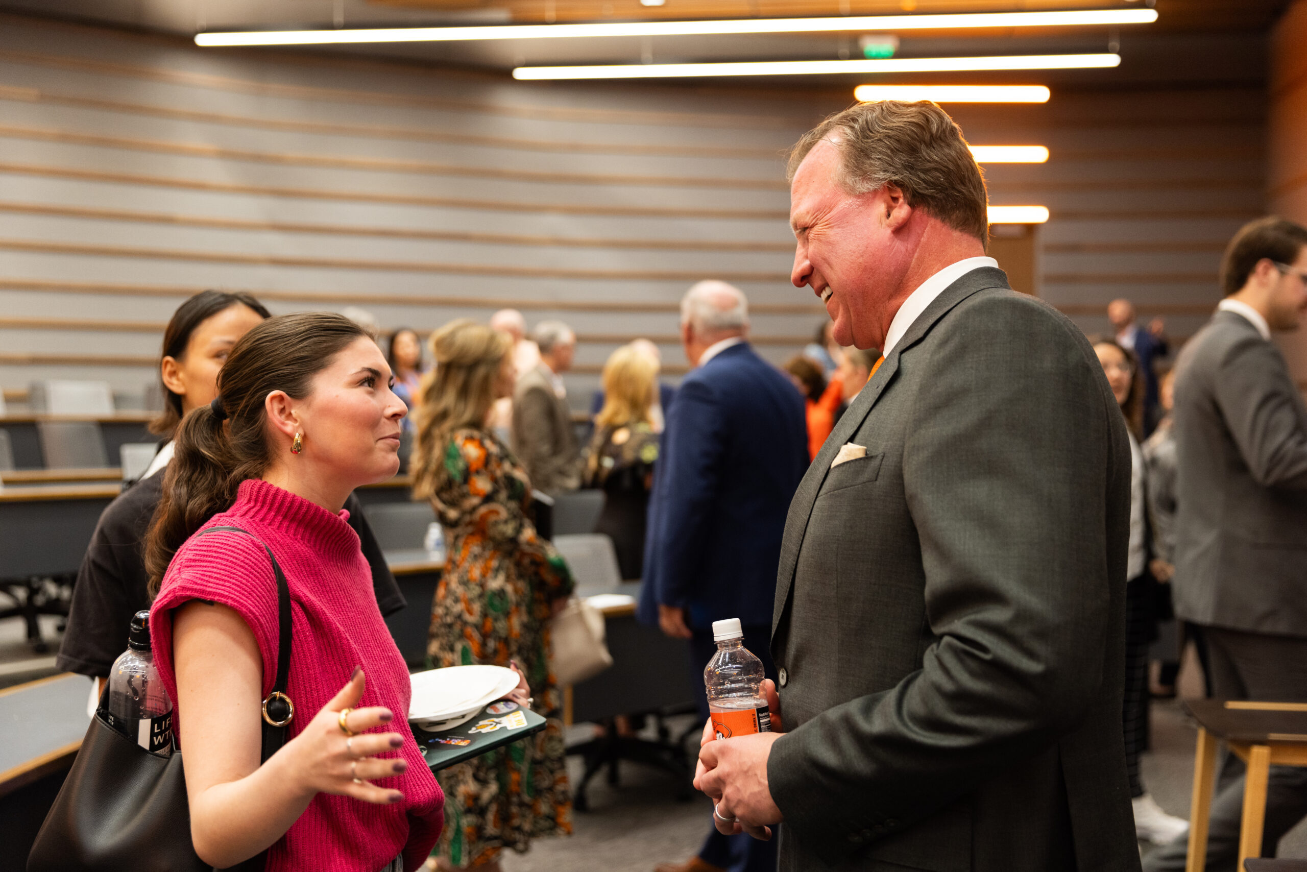 Joe Eastin speaking with two attendees at a social event